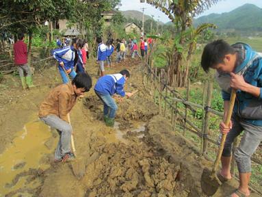 Học sinh bản Mỏ, xã Tân Lang, huyện Phù Yên tham gia làm đường về bản.